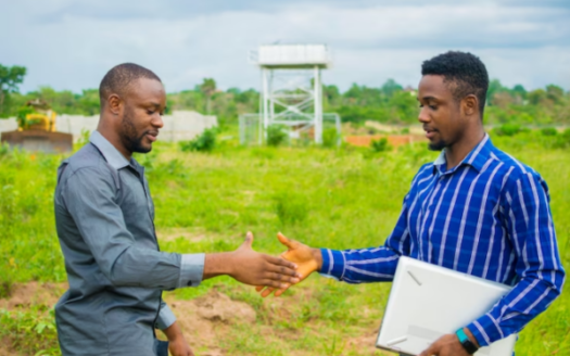 Two Dynamic African Entrepreneurs Sealing A Successful Land Banking Deal In Nigeria With A Firm Handshake, Symbolizing The Promising Opportunities In The Real Estate Sector
