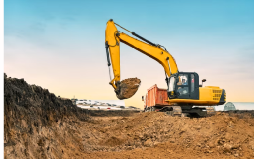 An image illustrating a large yellow construction excavator at a quarry construction site, highlighting the potential concerns associated with land grabbing